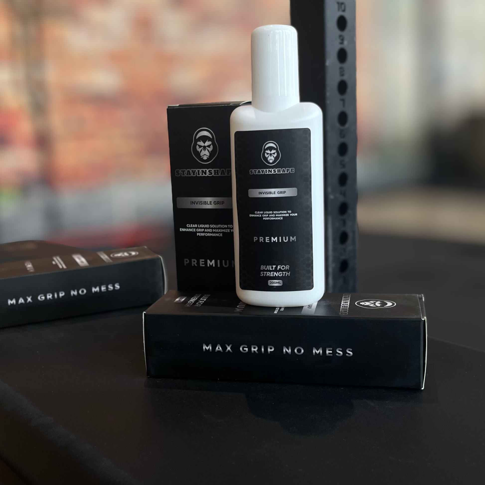 Bouteille de magnésie liquide Invisible Grip STAYINSHAPE posée sur son packaging noir premium, slogan ‘Max Grip No Mess’, solution 200 ml pour musculation et powerlifting.
